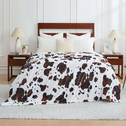 Bed with cow print comforter in a bedroom setting