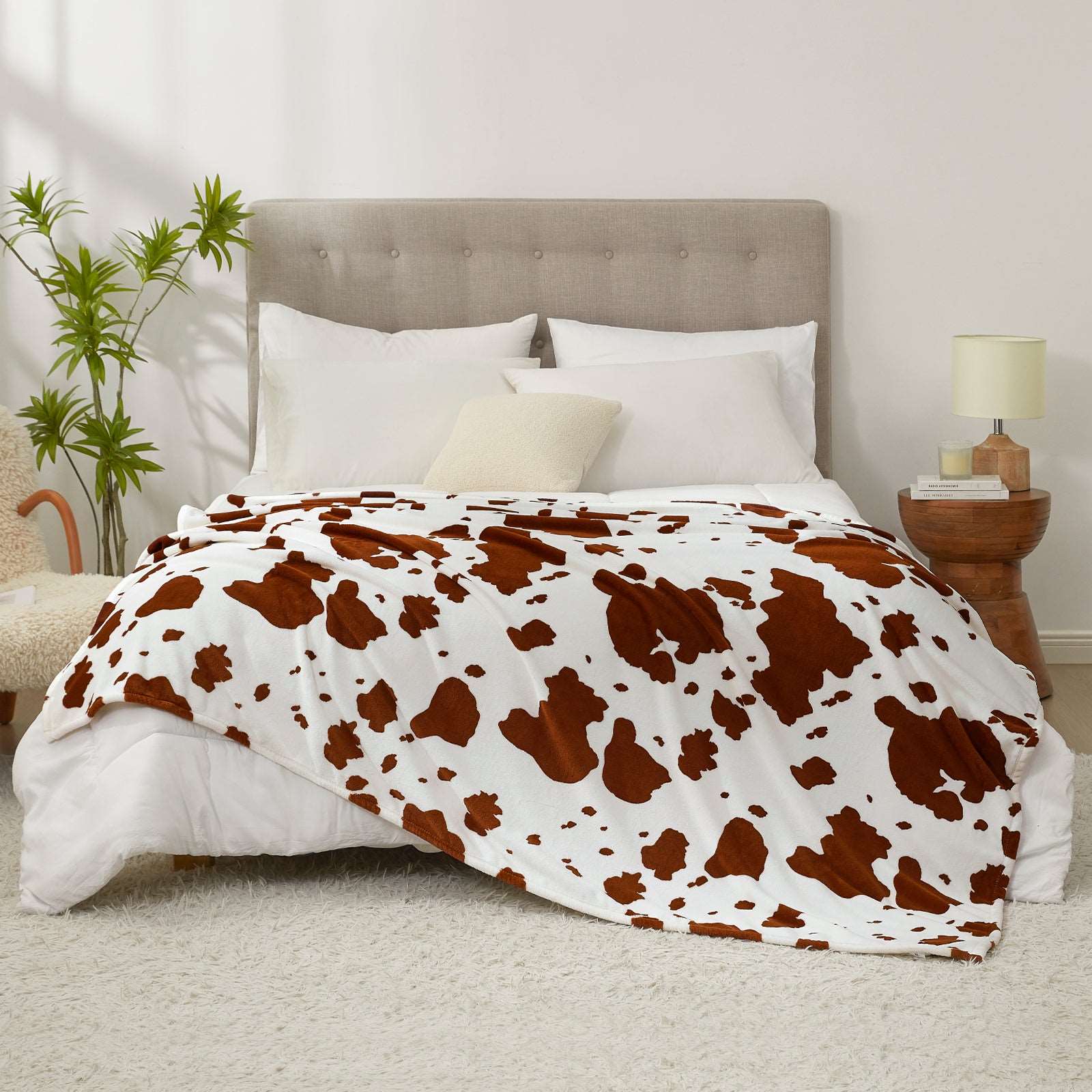 Bed with cow print comforter in a bedroom setting