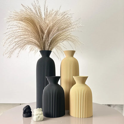 Josh & Tate - Minimalist Fluted Ceramic Vase Set - Set of black and gold vases with decorative elements on a light surface.