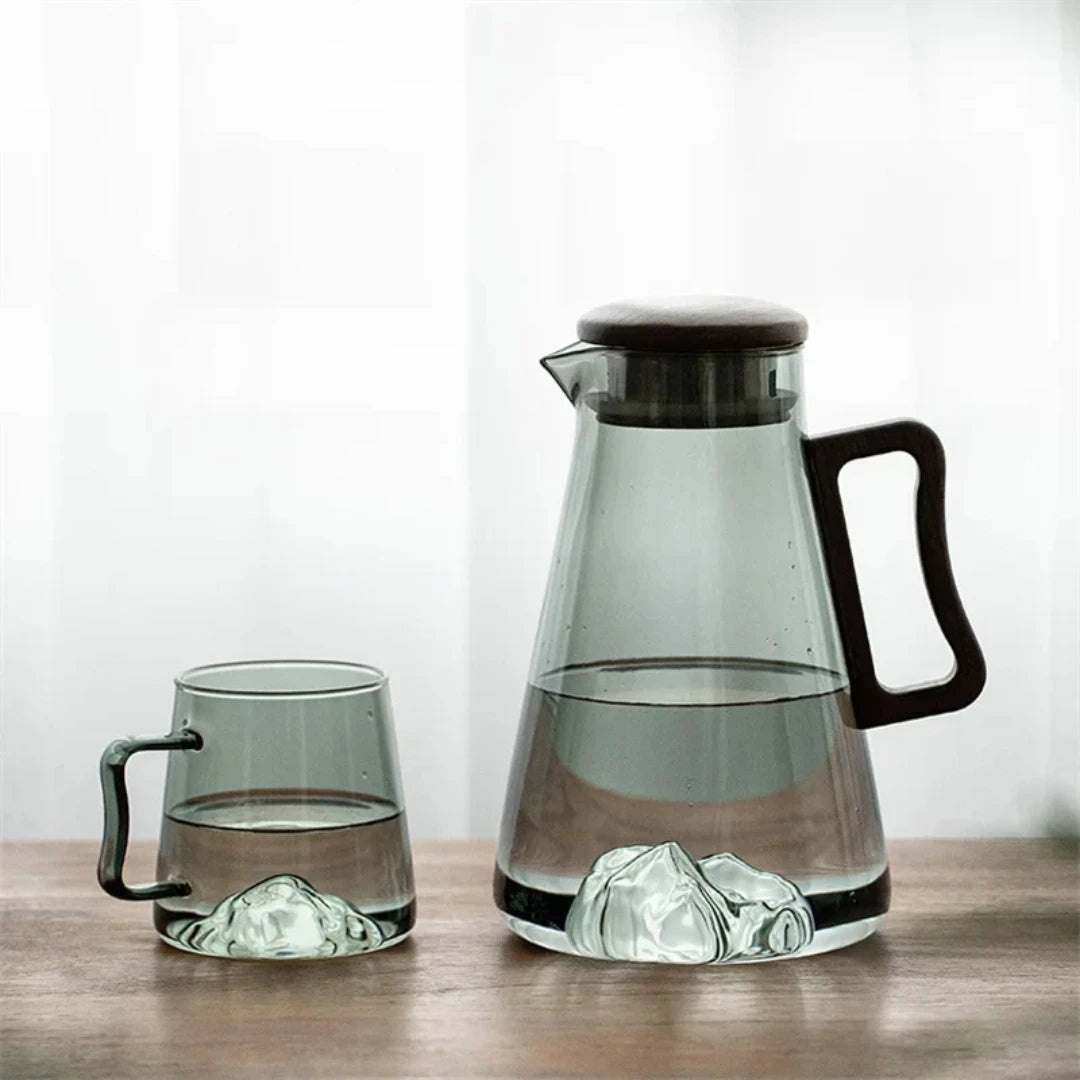 Josh & Tate - Montara Elegant Glass Pitcher - Clear glass pitcher and mug with black handles on a wooden surface