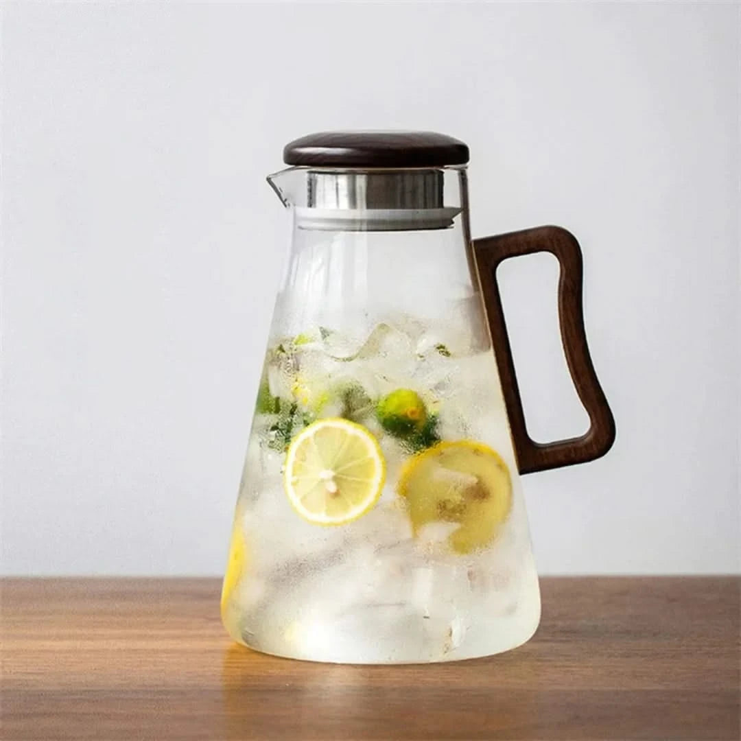 Josh & Tate - Montara Elegant Glass Pitcher - Glass pitcher with lemon slices and ice on a wooden surface