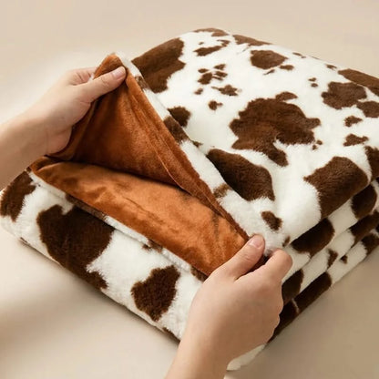 Josh & Tate MooWrap Cow Print Plush Blanket - hand showing double-layer thickness