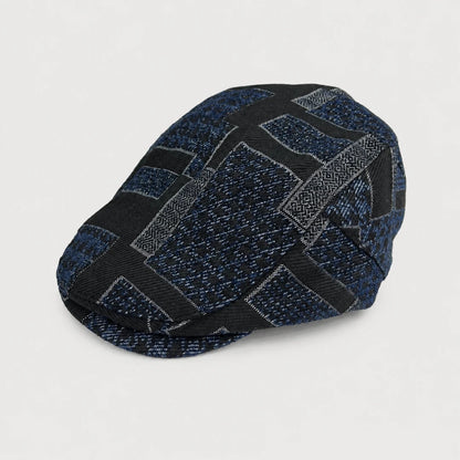 Josh & Tate - MosaicBrim™ Patchwork Flat Cap - A structured flat cap with a geometric woven pattern in navy blue, black, and gray, photographed on a clean white background.