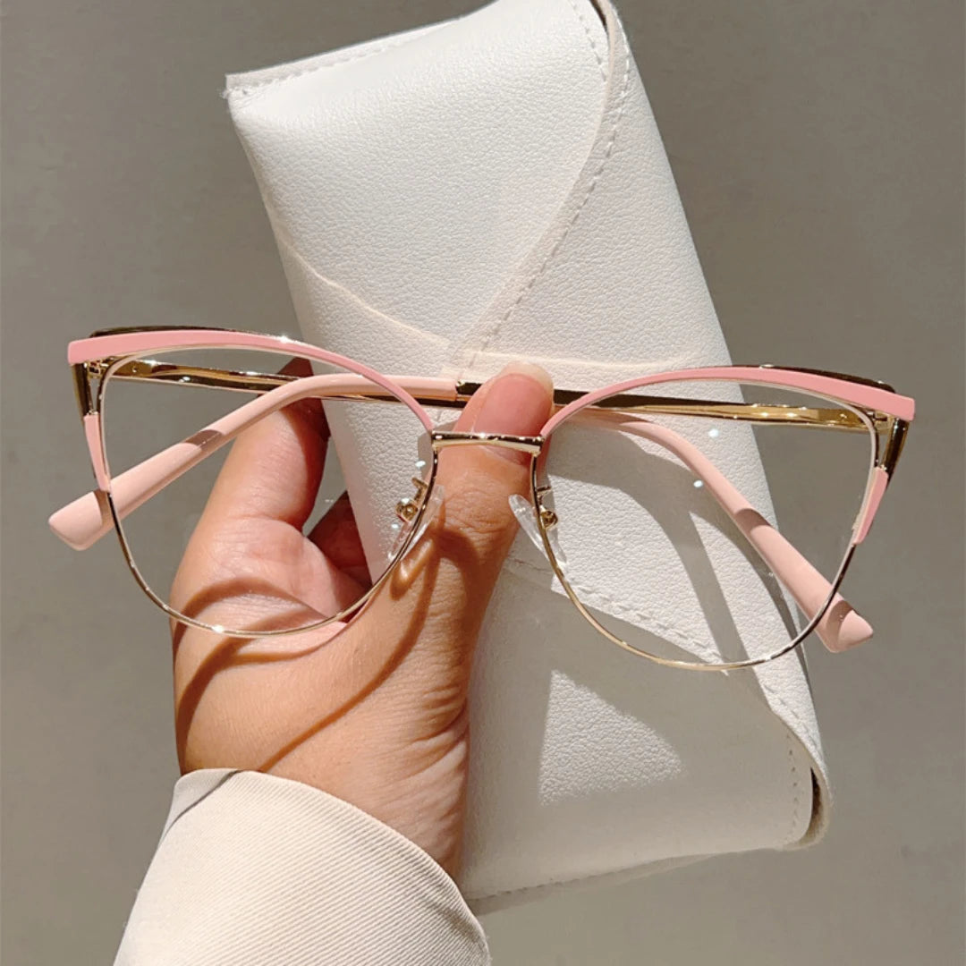 Josh & Tate - MuseCat™ Minimalist Cat-Eye Glasses - Hand holding pink cat-eye glasses with a white case in the background