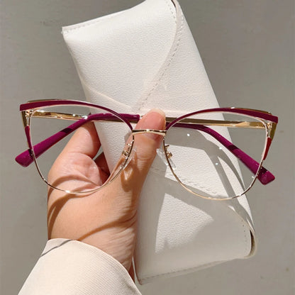 Josh & Tate - MuseCat™ Minimalist Cat-Eye Glasses - Hand holding a pair of glasses with gold frames and red accents against a white case.