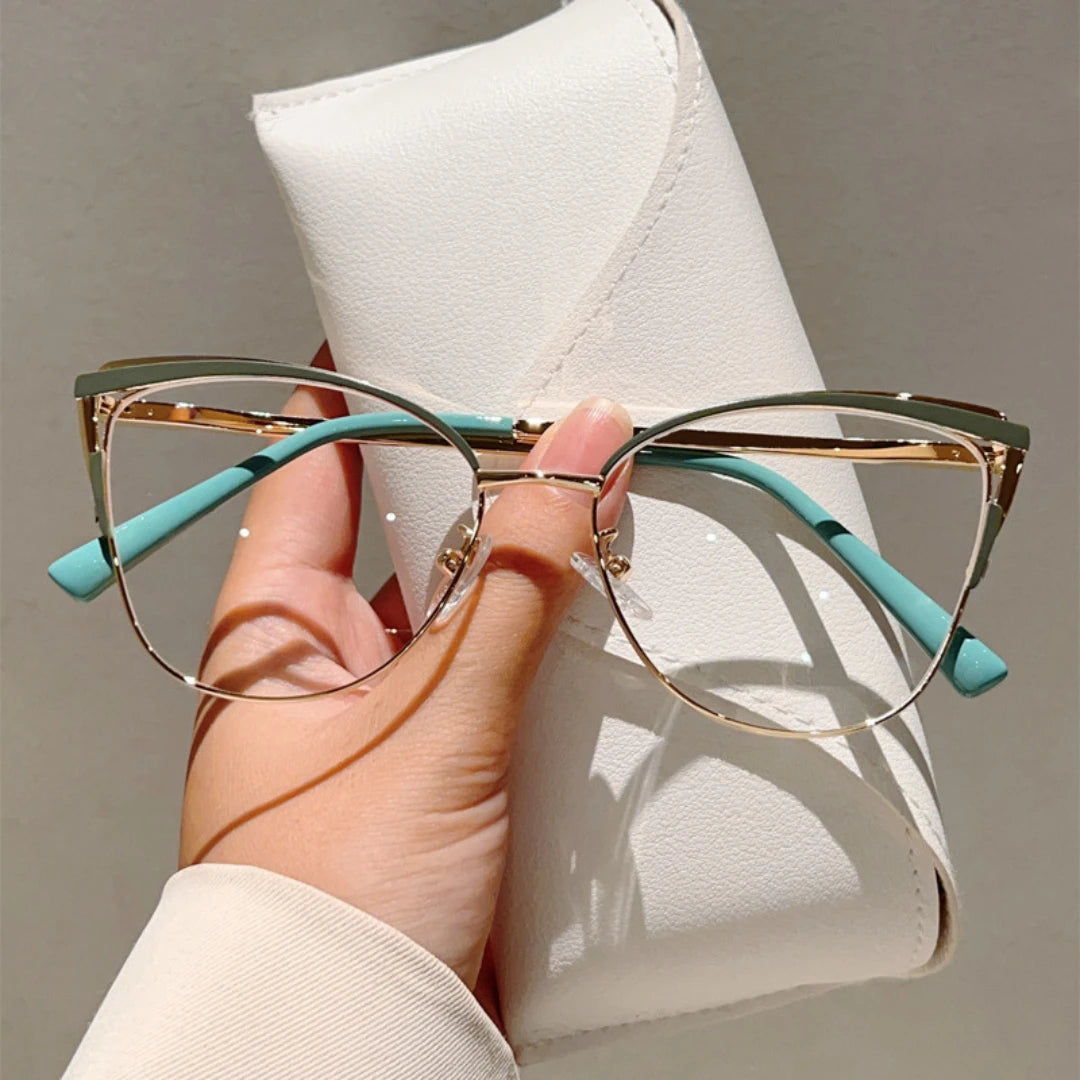 Josh & Tate - MuseCat™ Minimalist Cat-Eye Glasses - Hand holding a pair of cat-eye glasses with turquoise arms against a neutral background