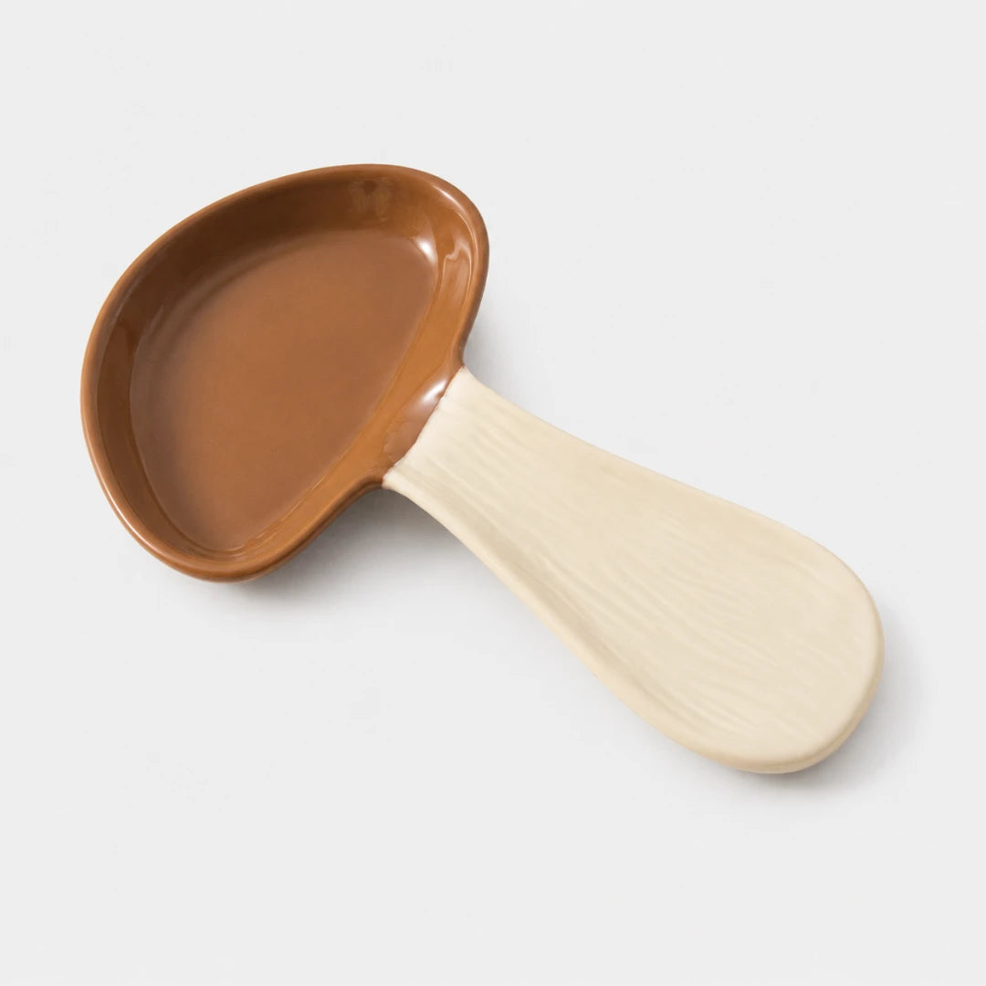 Josh & Tate - MushPerch™ Kitchen Spoon Holder - A ceramic spoon-shaped dish with a warm brown interior and a light cream-colored handle, shown on a plain light gray background.