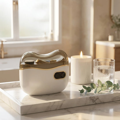 Josh & Tate - NailPod™ Automatic Nail Care System - White and gold electronic device on a marble surface with a candle and glass in the background.