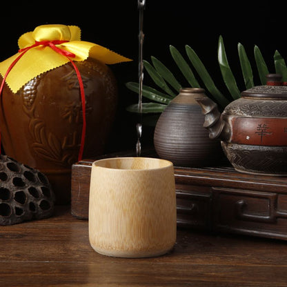 Ceramic jar with yellow lid and red ribbon, wooden cup, and other ceramic items on a dark background