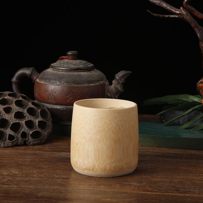 Wooden cup on a wooden surface with a teapot and decorative elements in the background