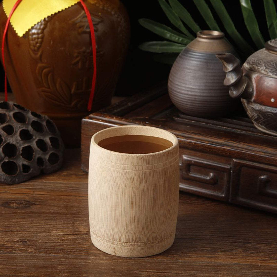 Wooden cup on a wooden surface with decorative items in the background