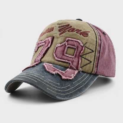 Josh & Tate - NewYork79™ Vintage Cap - A distressed baseball cap with a three-panel design in olive green, dusty rose, and washed dark gray. The front panel features distressed pink embroidered numbers '79' and cursive text, with contrast stitching throughout.