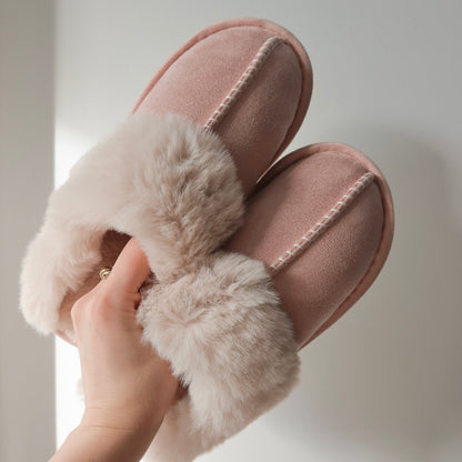Pink slippers with fluffy fur on a neutral background