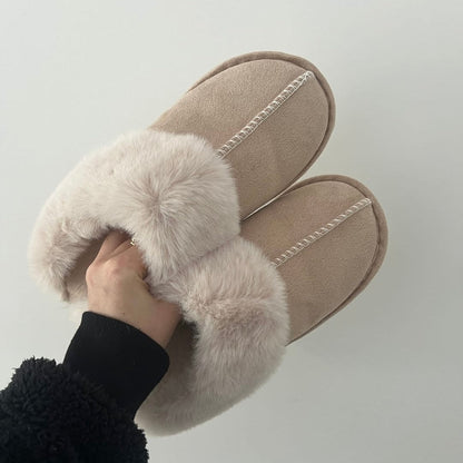Pair of beige slippers with fluffy fur on a white background
