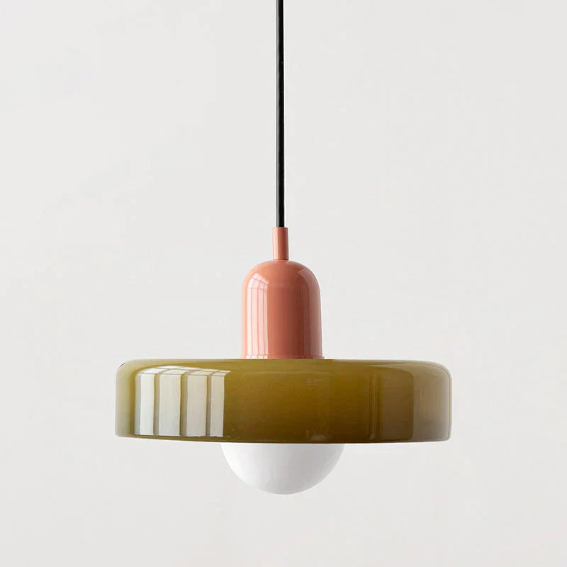 Pendant light with a pink fixture and green shade on a white background