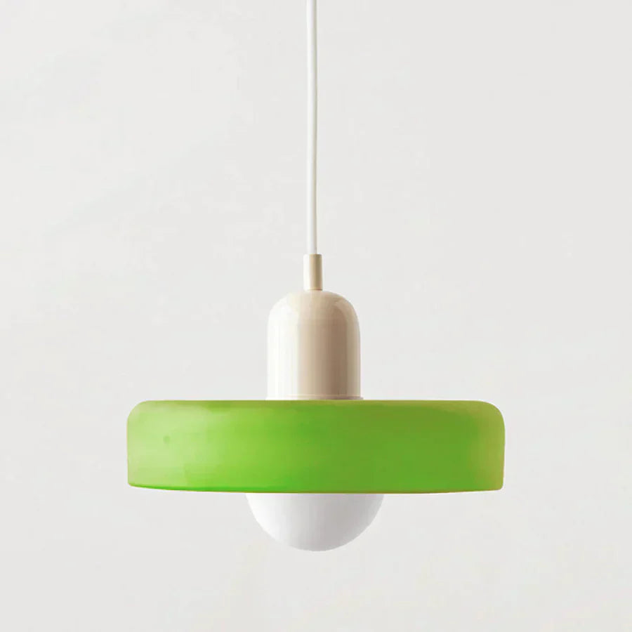 Green pendant light with a white bulb on a plain background