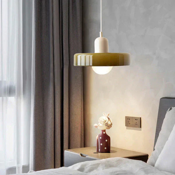 Modern bedroom with a pendant light, nightstand, and decorative vase.