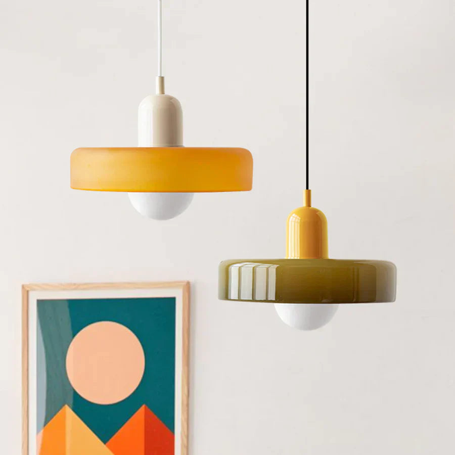 Two pendant lights hanging from the ceiling with a framed abstract art piece on the wall.