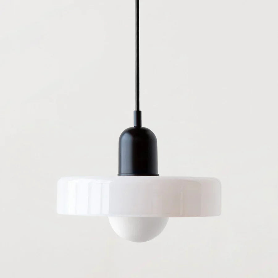 Modern pendant light with white shade and black fixture on a plain background