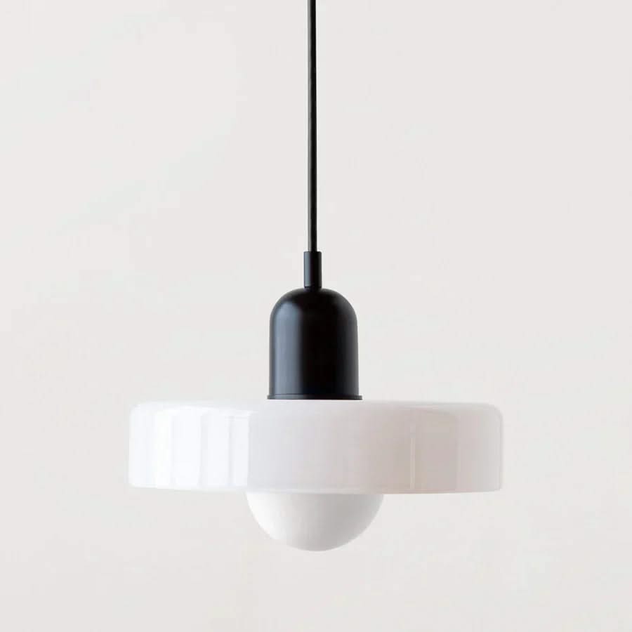 Modern pendant light with white shade and black fixture on a plain background