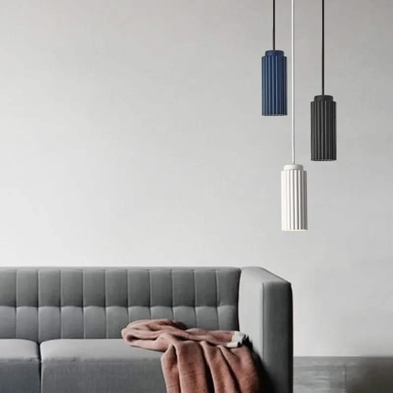 Gray sofa with a pink blanket and three pendant lights on a light gray background
