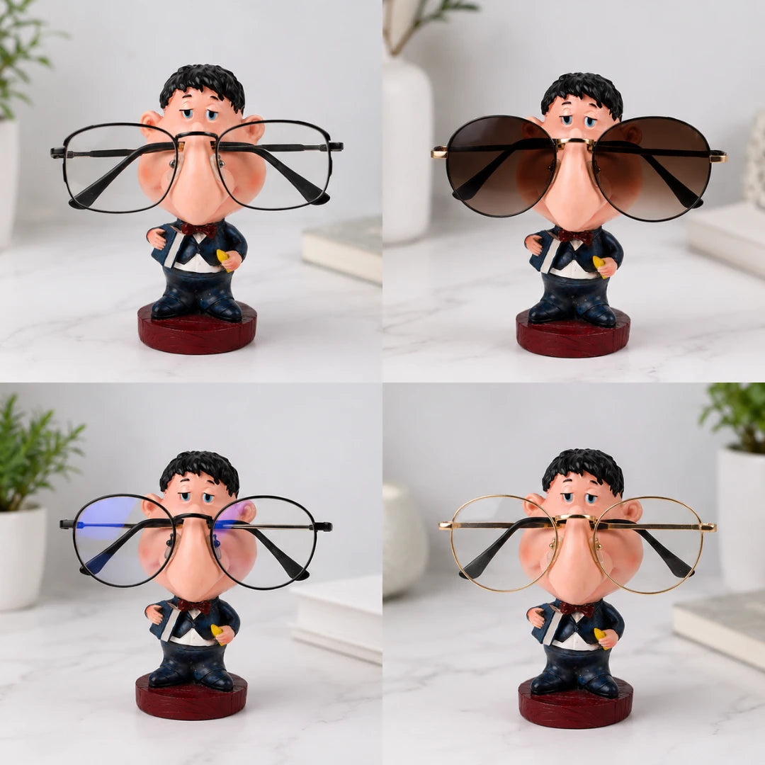 Josh & Tate - NoseNook™ Glasses Figurine Stand - Four views of a novelty glasses holder featuring a cartoon character bust wearing oversized eyeglasses, shown on a light marble surface with indoor decor in the background.