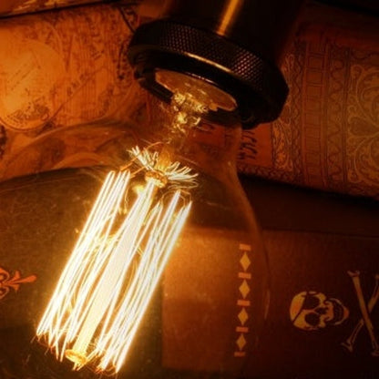 Vintage-style light bulb with intricate filaments on a textured surface