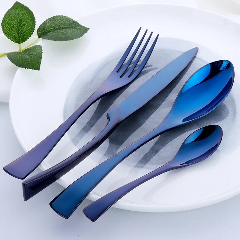 Set of blue cutlery on a white plate with green leaves.