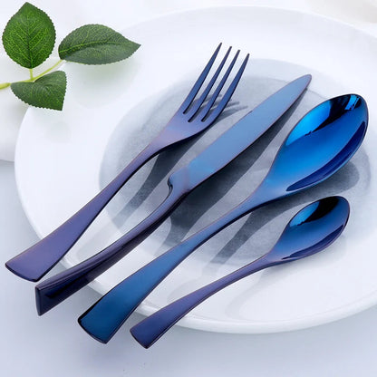 Set of blue cutlery on a white plate with green leaves.
