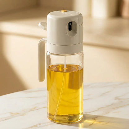 Josh & Tate - OilSwitch™ 2-in-1 Oil Dispenser - Transparent oil bottle with a white spray nozzle on a marble surface