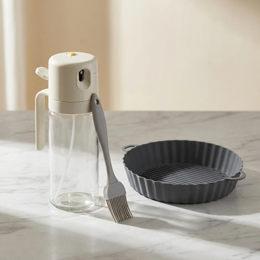 Josh & Tate - OilSwitch™ 2-in-1 Oil Dispenser - Kitchen utensils including a bottle, brush, and pan on a marble surface.