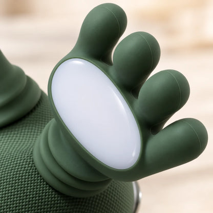 Josh & Tate - PawSoothe™ Shoulders and Neck Massager - Close-up of a green foot-shaped silicone accessory with a white oval center, shown against a softly blurred light beige background.