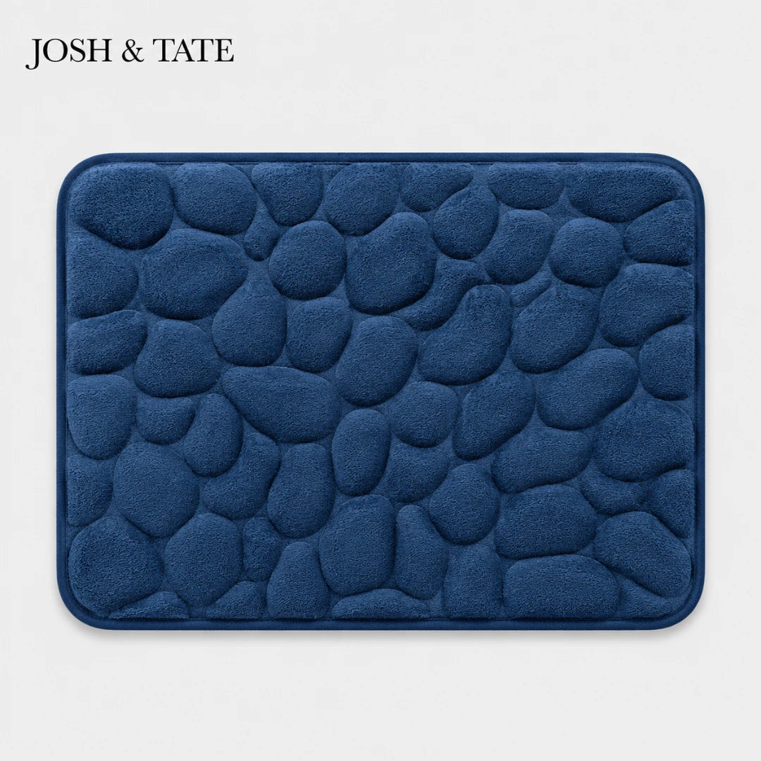 Josh & Tate - PebbleSoft™ Non-Slip Memory Foam Mat - Blue textured bath mat with 'JOSH & TATE' branding on a light gray background