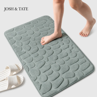 Josh & Tate - PebbleSoft™ Non-Slip Memory Foam Mat - Gray textured bath mat with a child's feet stepping onto it, on a light gray background.