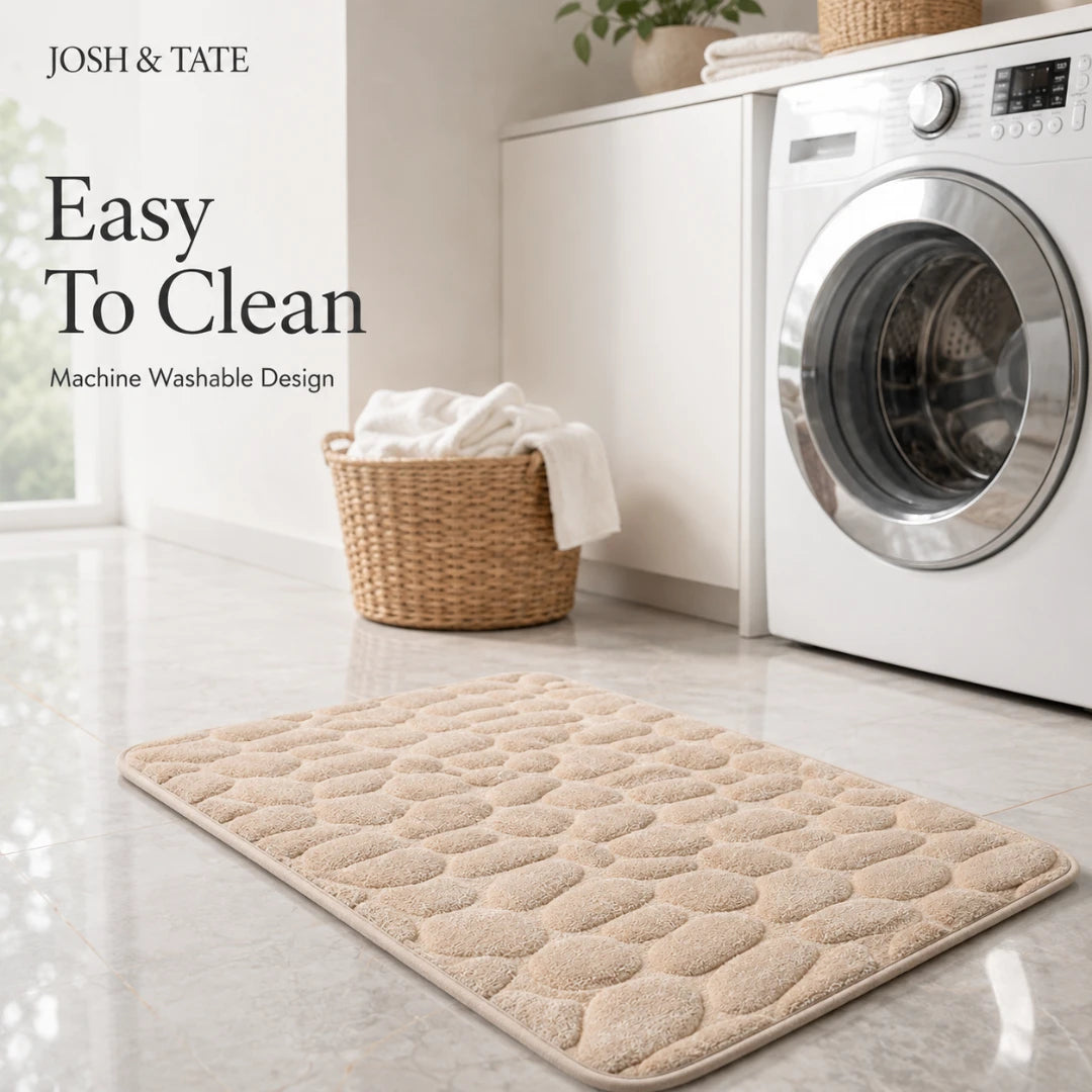 Josh & Tate - PebbleSoft™ Non-Slip Memory Foam Mat - Beige bath mat in front of a washing machine with 'Josh & Tate' branding.