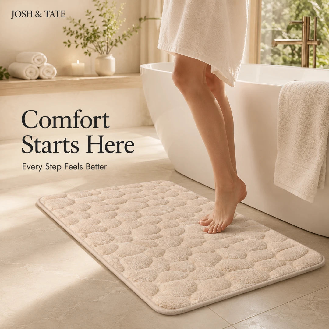 Josh & Tate - PebbleSoft™ Non-Slip Memory Foam Mat - Bathroom scene with a textured bath mat, bathtub, and towels, featuring 'Josh & Tate' branding.