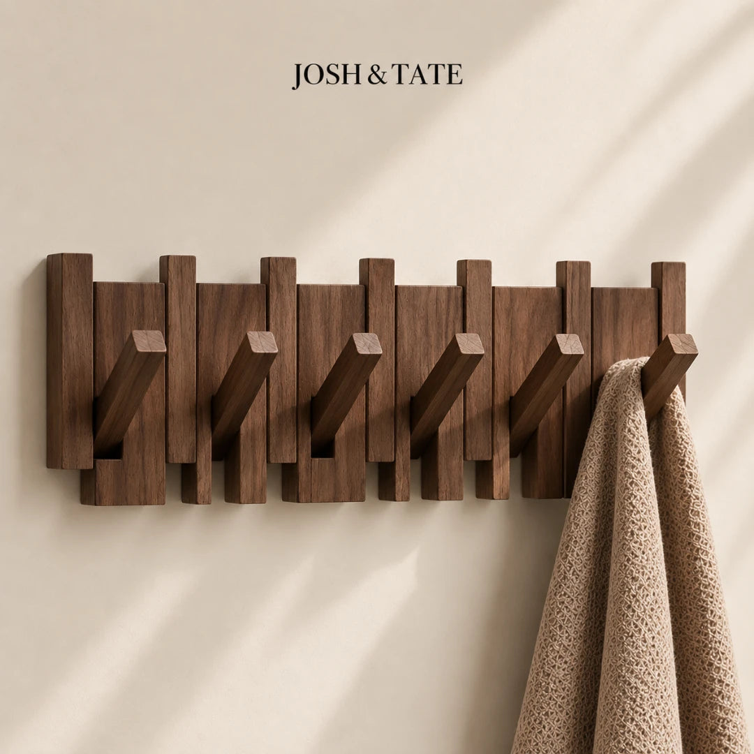 Josh & Tate - PianoHook™ Solid Wood Wall Rack - Wooden wall hook with multiple hooks on a beige wall, featuring the brand 'Josh & Tate'.
