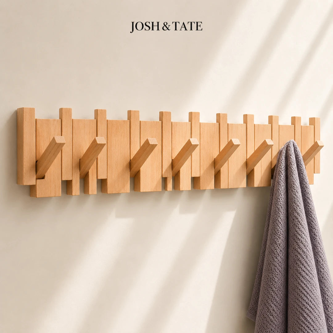 Josh & Tate - PianoHook™ Solid Wood Wall Rack - Wooden wall hook rack with multiple hooks on a beige wall, featuring the brand 'Josh & Tate'.