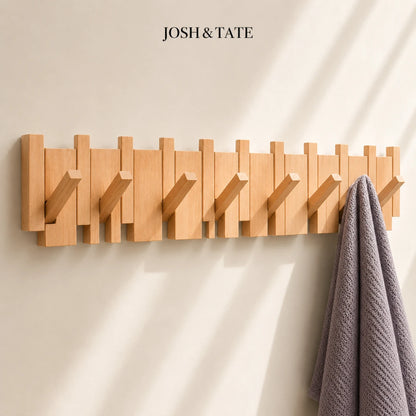 Josh & Tate - PianoHook™ Solid Wood Wall Rack - Wooden wall hook rack with multiple hooks on a beige wall, featuring the brand 'Josh & Tate'.