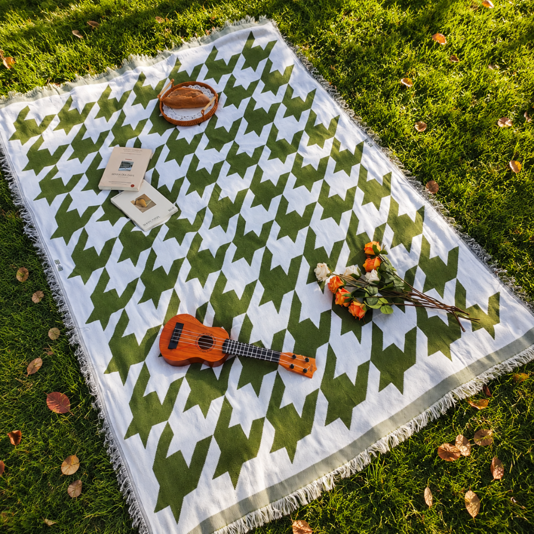 Josh & Tate - PicnicCo™ Woven Outdoor Blanket - Green and white patterned picnic blanket on grass with a ukulele and flowers.