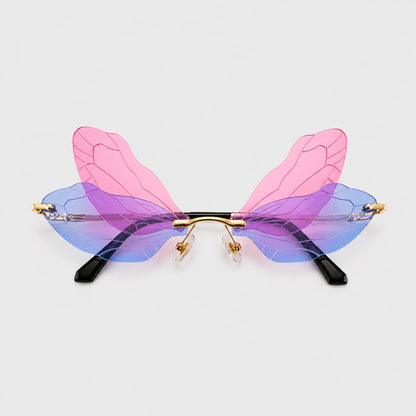 Josh & Tate - PixieFrame™ Butterfly Sunglasses - Unusual butterfly-wing style eyeglasses with translucent pink and blue wings, gold metal hinges, and black temple tips, shown on a light gray background.