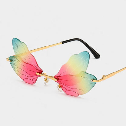 Josh & Tate - PixieFrame™ Butterfly Sunglasses - Intricate rimless butterfly wing sunglasses with a vibrant pink, yellow, and green gradient lens, gold metal frames, and black temple tips, shown on a light gray background.