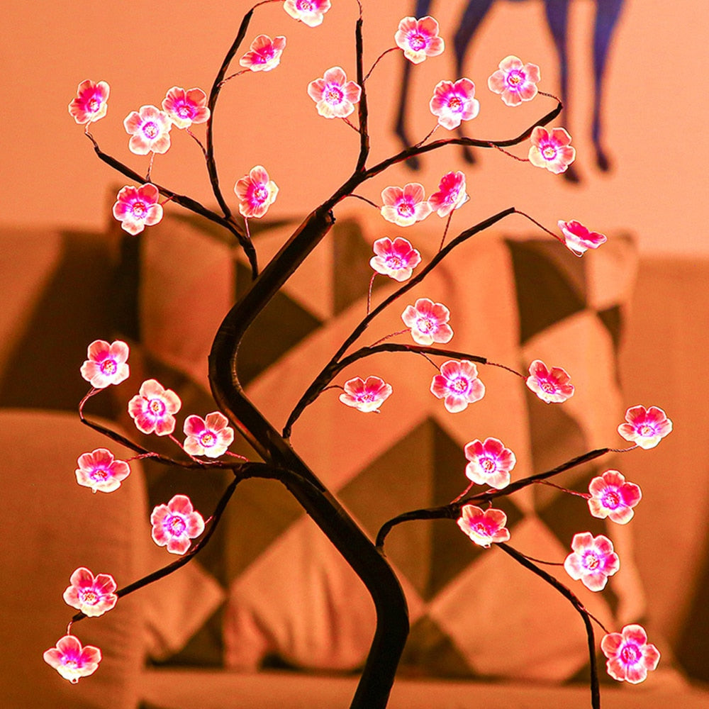 Decorative LED tree with pink flowers on a blurred background