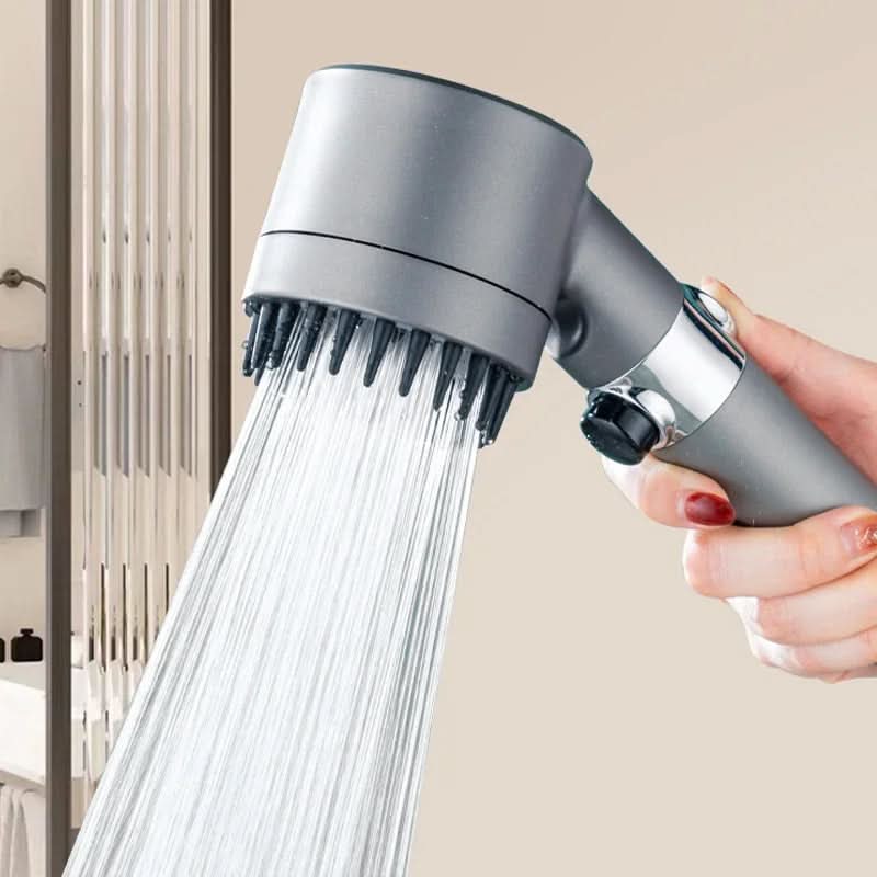 Handheld shower head with water flowing, held by a hand against a neutral background