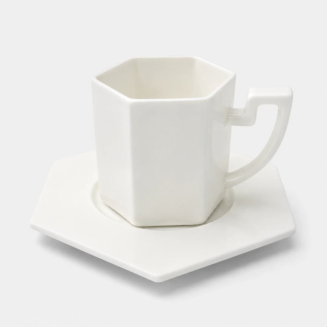 Josh & Tate - PrismCup™ Hexagon Cup & Saucer - A white hexagonal ceramic mug with a matching hexagonal saucer, photographed on a clean white background.