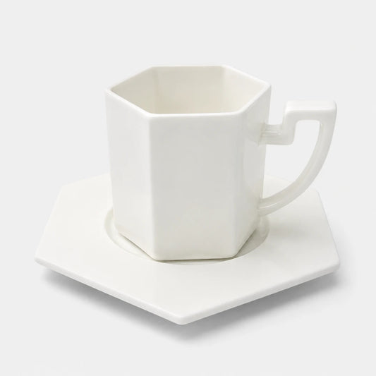 Josh & Tate - PrismCup™ Hexagon Cup & Saucer - A white hexagonal ceramic mug with a matching hexagonal saucer, photographed on a clean white background.