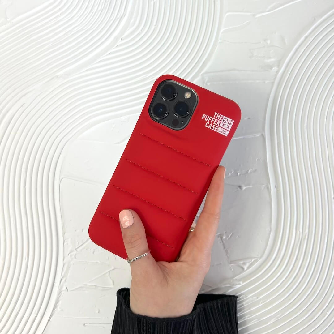 Red phone case held by a hand on a white textured background