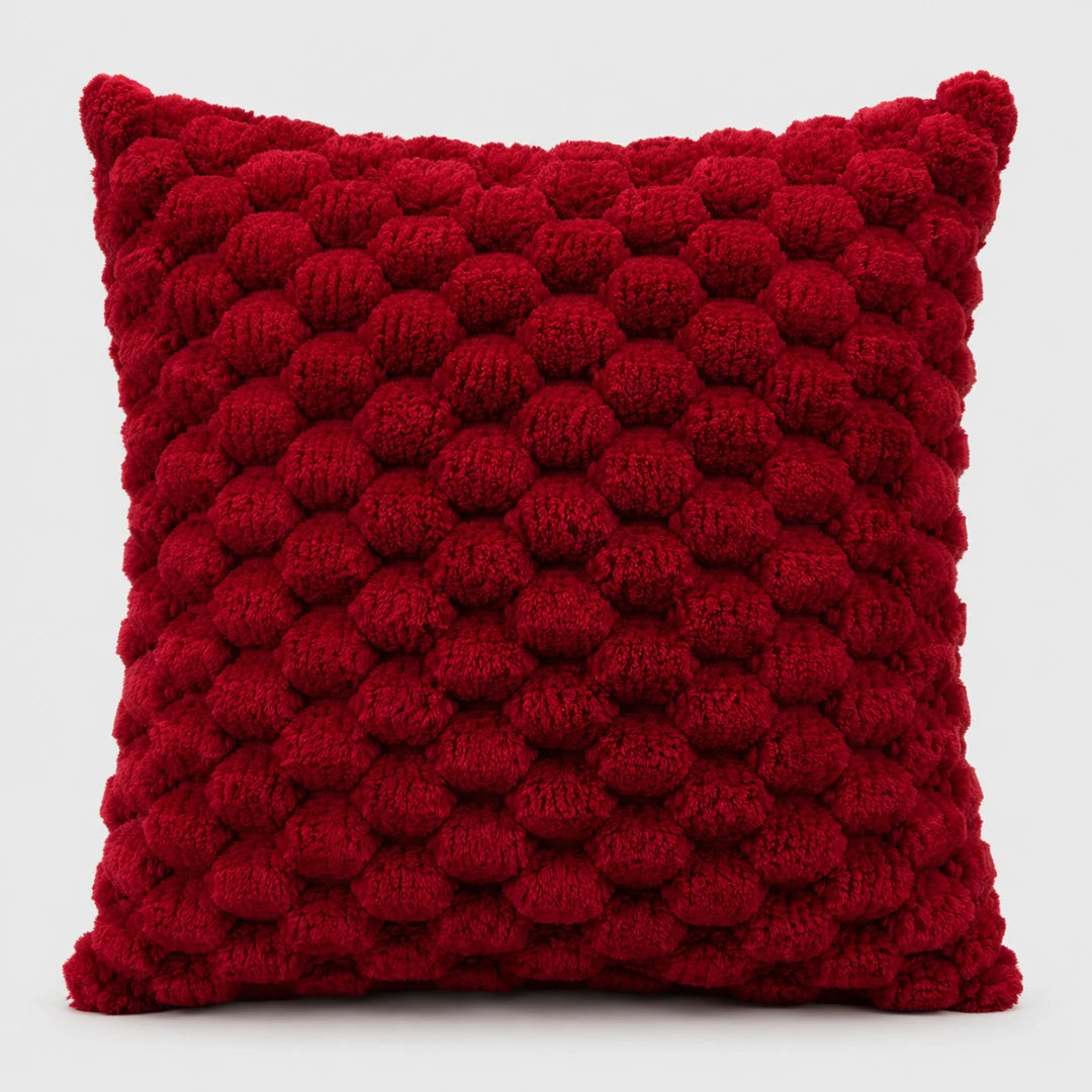 Josh & Tate - PuffKnot™ Bobble Cushion Cover - A square red throw pillow with a textured, raised pom-pom or bumpy knit pattern, shown against a plain light gray background.