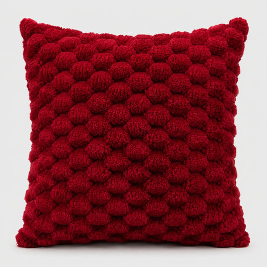 Josh & Tate - PuffKnot™ Bobble Cushion Cover - A square red throw pillow with a textured, raised pom-pom or bumpy knit pattern, shown against a plain light gray background.