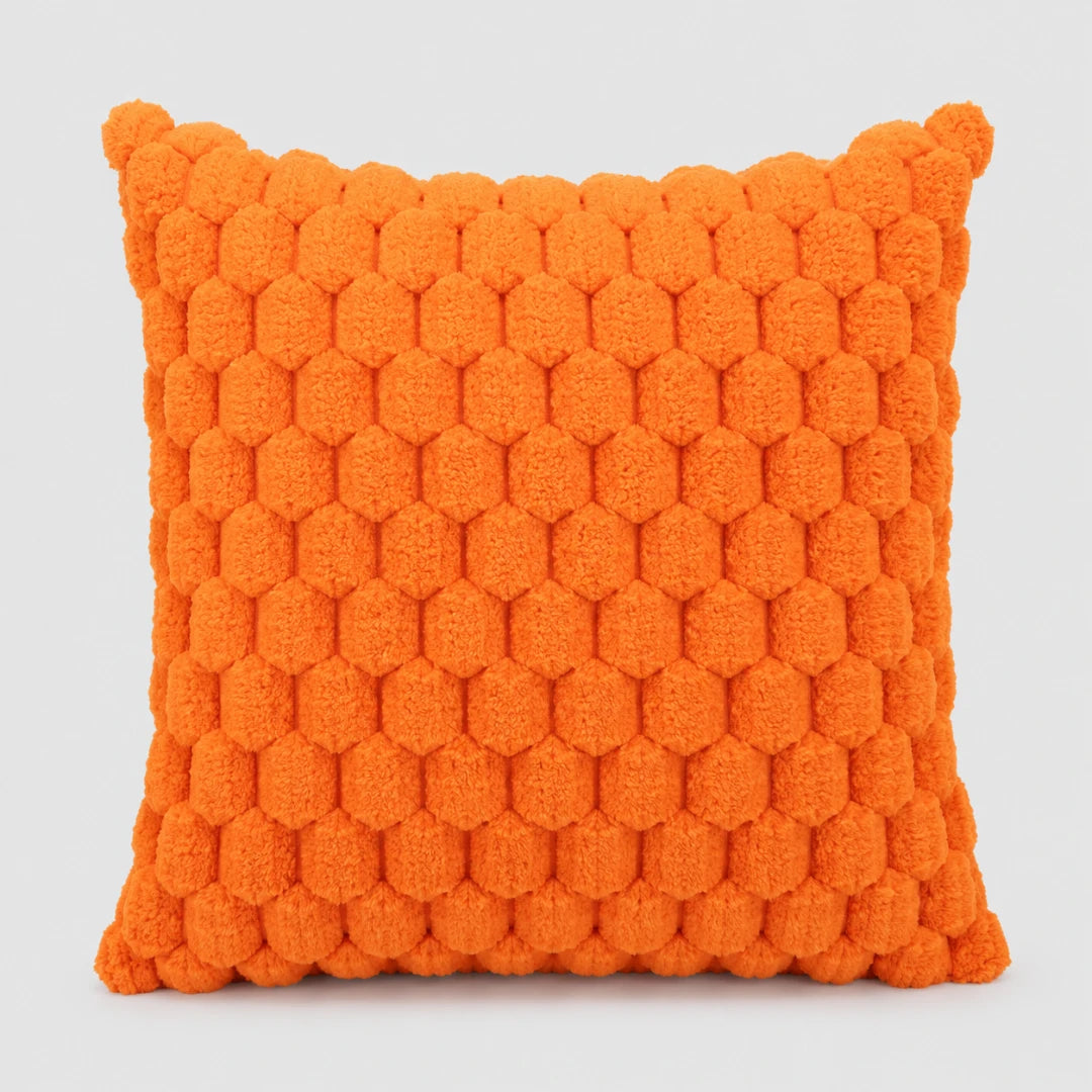 Josh & Tate - PuffKnot™ Bobble Cushion Cover - A square orange throw pillow with a textured, raised honeycomb or pom-pom style pattern, shown against a neutral light gray background.